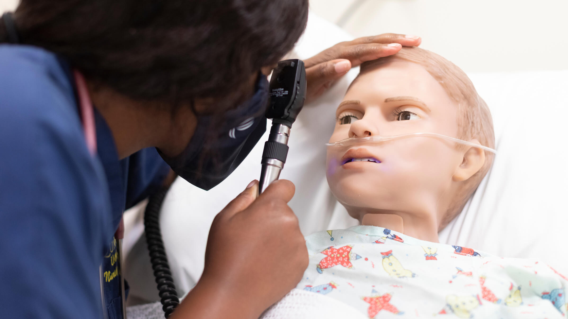 A student examines a simulated manikin.