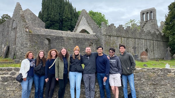 A group of QU Law students in front of stone ruins