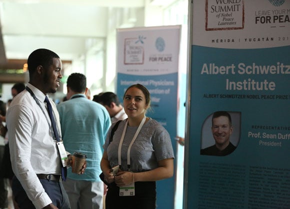 Two students converse with each other at the World Summit of Nobel Peace Laureates