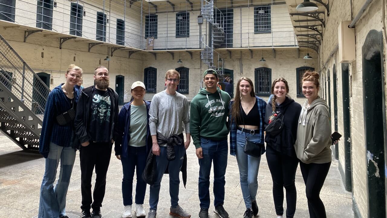 Group of School of Law students standing in an old prison yard