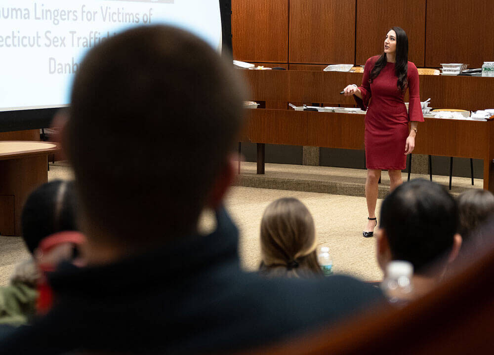 A law student makes a presentation in front of her class on human trafficking
