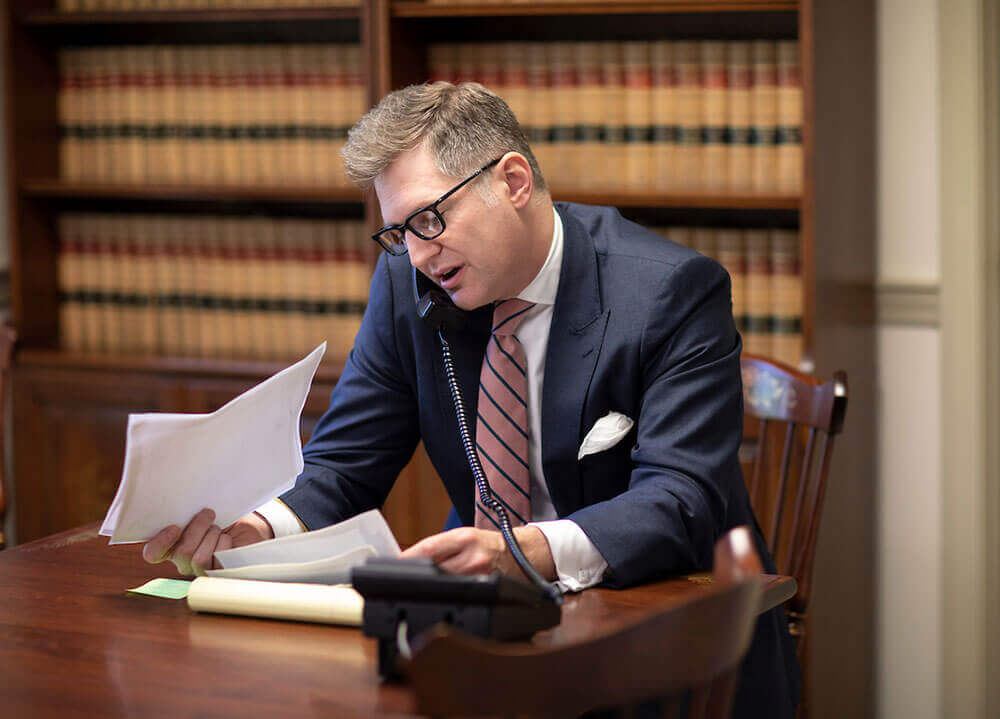 A School of Law alumni talks to someone on the phone in his large law office in Cheshire, Connecticut