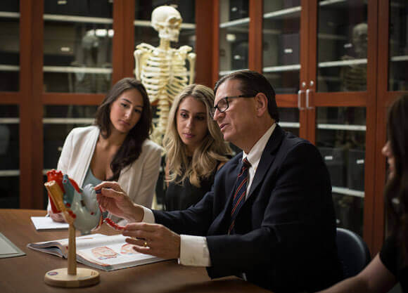 A faculty member works with law students in the model demonstration room.
