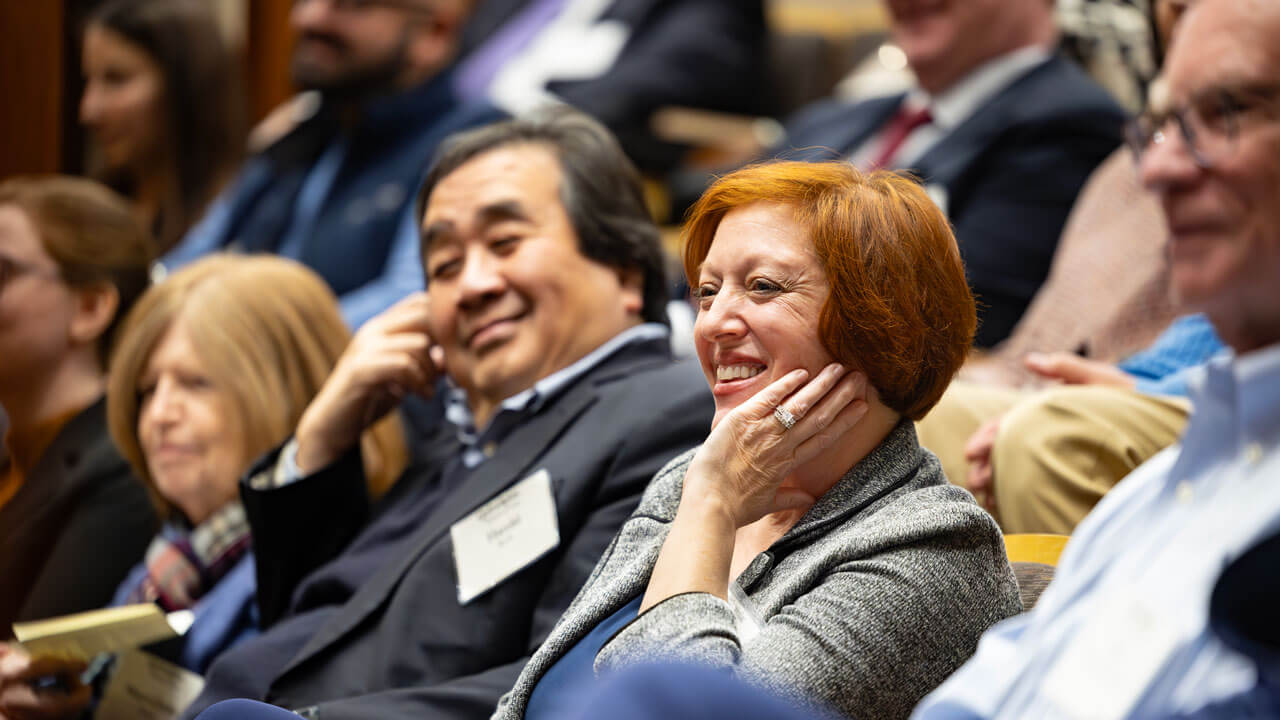 Attendees of the inaugural alumni association awards smile and clap.