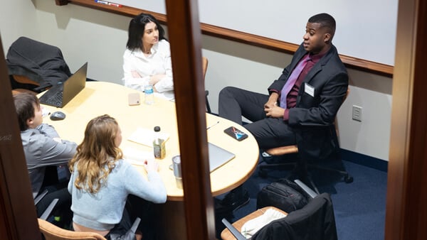 Students discuss new concepts in a meeting room